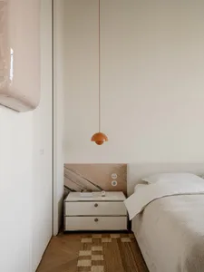 Cozy bedroom with a white bed, dresser, and lamp, set against a white background