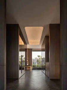 A bright and welcoming hallway with a wooden floor, lined with open doors and illuminated by natural light