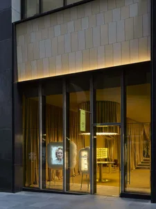 A retail store with a glass door and a display of a woman's face on a screen, creating a modern and stylish atmosphere