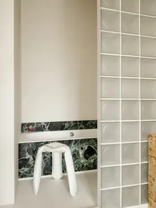 A modern bathroom with a white toilet and sink, marble countertop, and dim lighting creating a cozy atmosphere