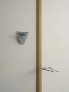Bathroom with a wooden wall, metal towel rack, sink, and toilet, featuring a blend of traditional and contemporary elements