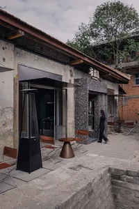 Outdoor restaurant with stone walls, wooden furniture, and natural materials creating a cozy and inviting atmosphere