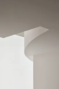 A minimalist room with a curved wall, clean lines, and natural light, creating a bright and airy atmosphere