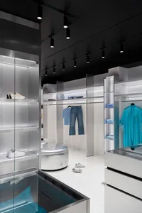 Well-lit retail store with modern design, blue jeans on the floor, shoe display, and inviting atmosphere