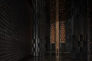 A dimly lit hallway with modern stone-like columns and a minimalist aesthetic