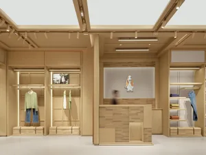 一間木材內裝修的商店，具有大理木展示柜和人體模型穿著衣服，自然光從窗戶透入