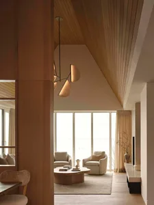 Bright and airy living space with a large window, modern furniture, and natural light, decorated with a vase, bowl, and potted plant