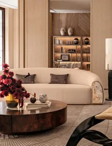 Comfortable living space with a large white couch, coffee table, fireplace, and decorative items, well-lit and inviting