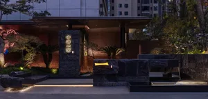 A modern building with a stone facade, brick wall, and dim lighting creating a moody atmosphere