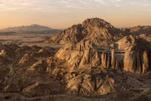 A dramatic rock formation in an outdoor environment with earth tones and natural lighting