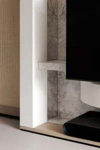 Cozy living room with a white fireplace, wooden cabinet, and flat screen TV mounted on the wall