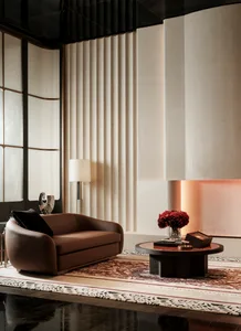 Cozy living room with a brown couch and chair, a fireplace, and a large window providing natural light