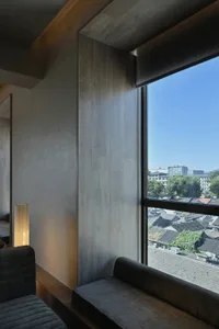 Comfortable living space with a couch and chair near a large window, well-lit with natural light