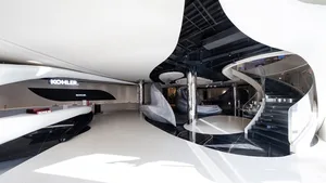 A modern showroom filled with luxury vehicles, including cars and motorcycles, displayed in an artistic manner to showcase their features and design