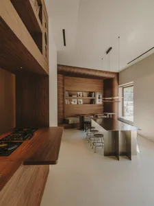 Warm and inviting kitchen and dining area with wooden cabinets, a wooden countertop, and a dining table surrounded by chairs