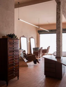 A hair salon with three chairs and two mirrors, set against a clean and well-maintained wooden floor