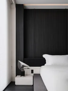 Cozy bedroom with a black bed frame, white comforter, and natural light from a window with white curtains
