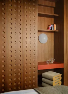 Cozy room with wooden walls, a wooden shelf, a wooden table, and a towel on the floor, with a focus on organization and storage