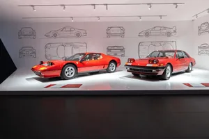 A well-lit showroom displaying sports cars on a white surface, highlighting their unique features and design