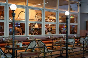 A modern restaurant interior with comfortable seating, soft lighting, and warm ambiance, featuring a variety of chairs and dining tables