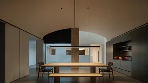 A spacious dining area with a wooden table and chairs, a bench, and a large window allowing natural light to fill the space