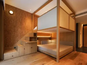 Cozy bedroom with a wooden bed frame, wooden floors, and a loft bed under a window, with a desk and chair