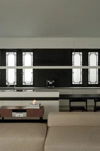 Modern kitchen with a black and white color scheme, featuring a sink, dining table, counter, and bookshelf, with a minimalist and sleek design and dim lighting