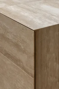 A modern kitchen with a marble countertop and wooden drawer, featuring clean lines and minimalistic design, with natural sunlight creating a warm atmosphere