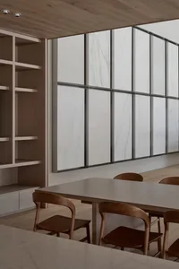 餐廳有木地板、木桌椅和椅子，周圍有長椅，氣氛溫暖，壁紙似大理石
