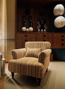 A well-lit living room with a yellow and white striped chair, a table, and a baseball glove on display, creating a cozy atmosphere with a mix of yellow and white colors