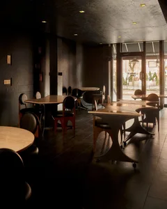 Dimly lit restaurant interior with semi-circular seating area, black and white furniture, and decorative items