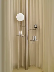 Modern bathroom with a wall-mounted mirror, shelf, and shower curtain, featuring dim lighting and a focus on functionality