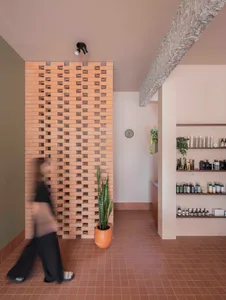 A spa room with a brick wall, decorative bottles, and vases, creating a calm and inviting atmosphere