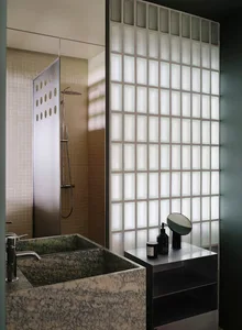 Modern bathroom with a marble sink, a shower, and a mirror above the sink, set against a green color scheme