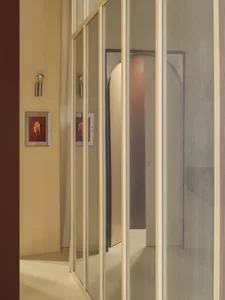 Wooden hallway with a brown color, a doorway, and a mirror, capturing the reflection of the hallway in the mirror with dim lighting