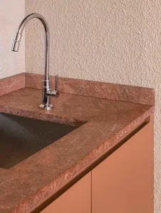 A bathroom with a marble sink and countertop, brown color scheme, and dim lighting