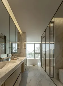Modern bathroom with a marble countertop, white bathtub, and large mirror, set against a bright and inviting background