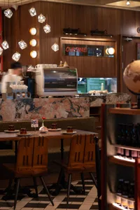 Cozy restaurant dining area with wooden furniture, a table, and dim lighting, creating an intimate atmosphere