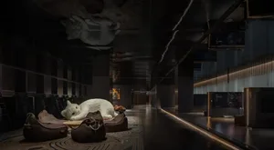 A cozy hotel lobby with a large white teddy bear lying on a couch, surrounded by plush furniture and a warm atmosphere