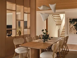 Dining room with a wooden table and chairs, a potted plant, and warm lighting