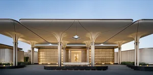 Large, modern building with a glass exterior and a well-lit, open interior space featuring a large window
