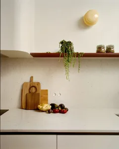 A well-lit kitchen counter displaying a variety of fresh fruits and vegetables on a marble surface