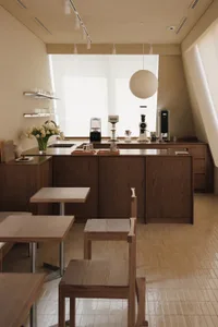Warm kitchen with wooden cabinets, tile floor, dining table, and kitchen appliances