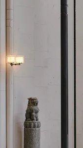 A dimly lit living space with a stone wall, stone floor, and a stone statue on a pedestal