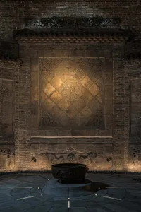 A stone wall with a stone bowl or vase on it, set in a darkened environment with dramatic shadows and textures