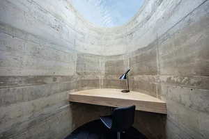 Small office space with a wooden desk and chair in a dimly lit room