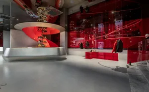 一間採用紅白色調的現代商店，展示圓形展示區和穿著黑色服裝的人形展示品
