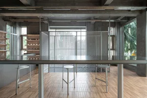 Warm and inviting kitchen dining space with a wooden floor, a counter with stools, a table, and chairs, and bottles on the counter