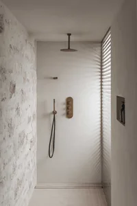 Modern bathroom with a corner shower and towel rack, well-lit and water-resistant materials