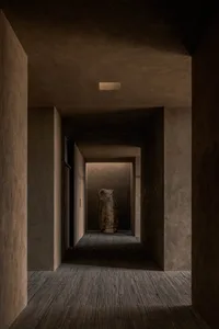 Dimly lit hallway with a stone wall and floor, creating a mysterious atmosphere